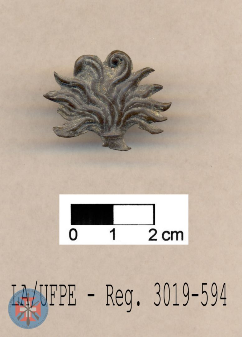 Insígnia militar do Brasil Império: fragmento de plaqueta representando granada em chamas. Séc. XIX.